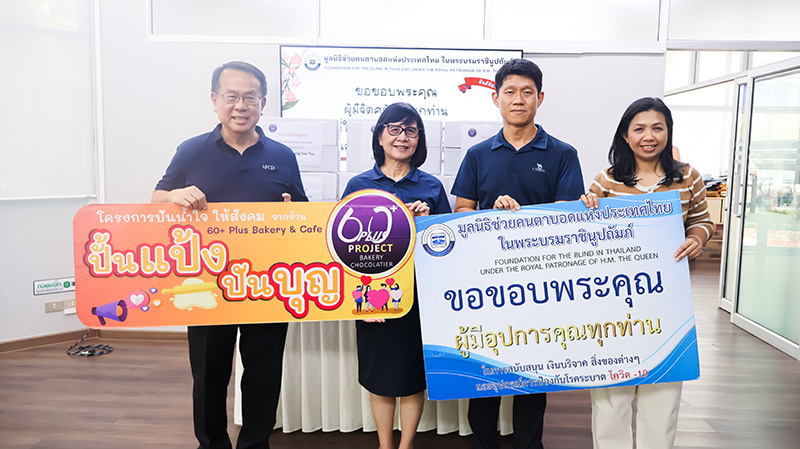 Picture 1: A group photo featuring Mr. Piroon Laismit, Executive Director of APCD (far left), and representatives from the Bangkok School for the Blind (center) holding a "Pun Pang, Pun Boon" campaign sign, alongside Ms. Wilailekha Somprach, Manager of APCD 60+ Plus Projects (far right), holding a thank-you sign, with boxes of bread stacked in the background.