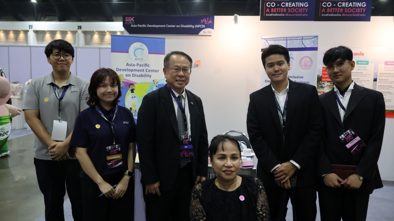Mr. Piroon Laismit and participants pose for a photo at the APCD booth.