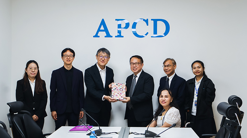 Picture 1: From left to right, Ms. Nuntaporn Sittidetboripat, Mr. SAKUDO Shunsuke, Mr. KOBAYASHI Hiroyuki (left) and Mr. Piroon Laismit (right), both holding a gift together, Mr. Somchai Rungsilp, Ms. Nongnuch Maytarjittipun (seated in a wheelchair in front of Mr. Somchai Rungsilp), and Ms. Siriporn Praserdchat pose for a group photo
