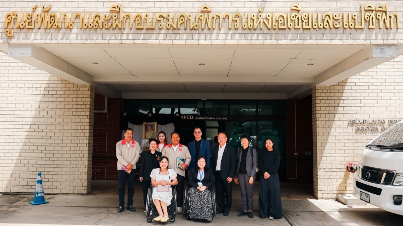 Group photo of the Committee on Social Welfare and APCD in front of the APCD building, with the APCD sign visible.