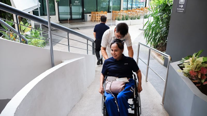 Picture 4: Mr. Asdang Sukwises pushes Ms. Nongnuch Maytarjittipun in her wheelchair