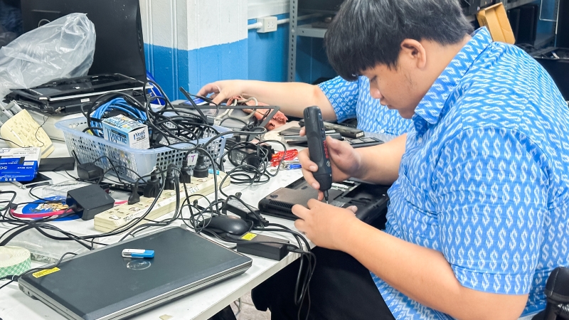 A student practices laptop repair during the class