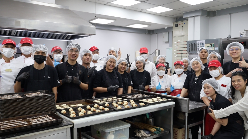 Participants pose for a photo with the doughs before put it in the oven.