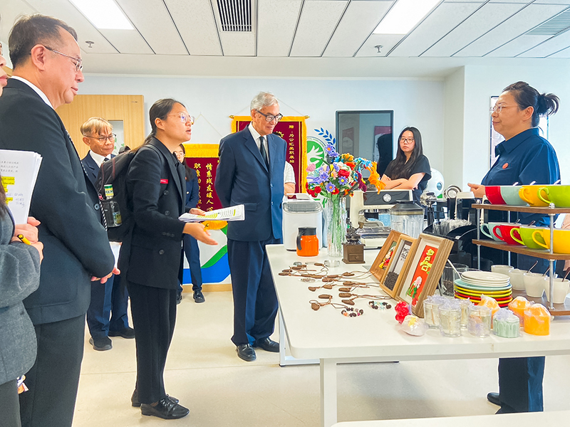 Picture 5: Dr. Tej Bunnag (center), Mr. Piroon Laismit (left), and Mr. Somchai Rungsilp (left, in the background) look at products made by persons with disabilities