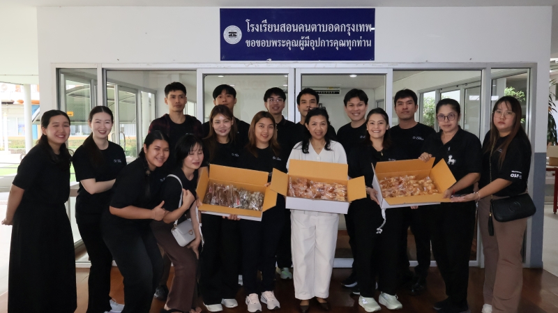 Group photo of the Ascott Thonglor Bangkok team, APCD team, and The Bangkok School for the Blind team holding freshly baked bread donated to the school.