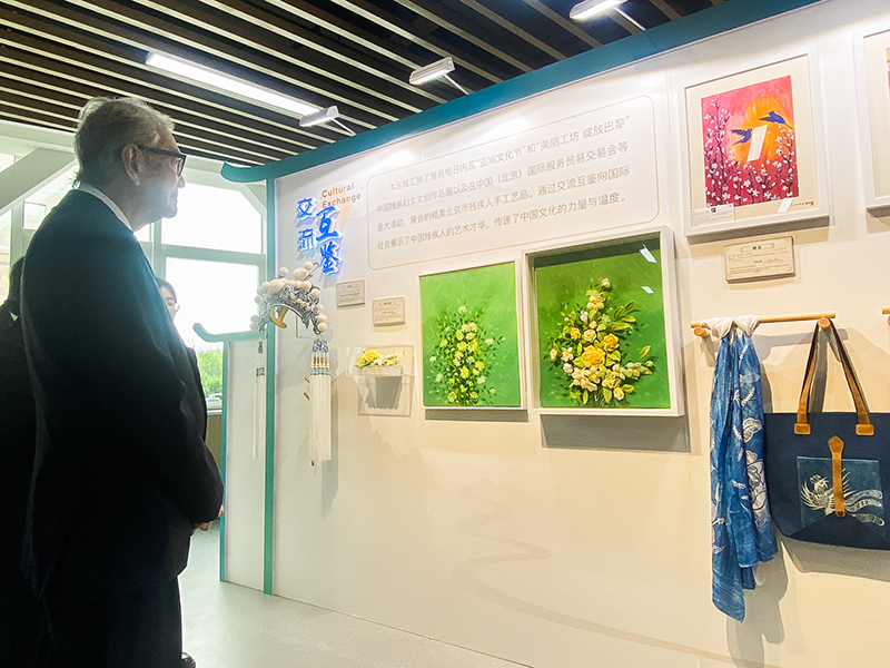 Picture 7: Dr. Tej Bunnag looks at products made by persons with disabilities