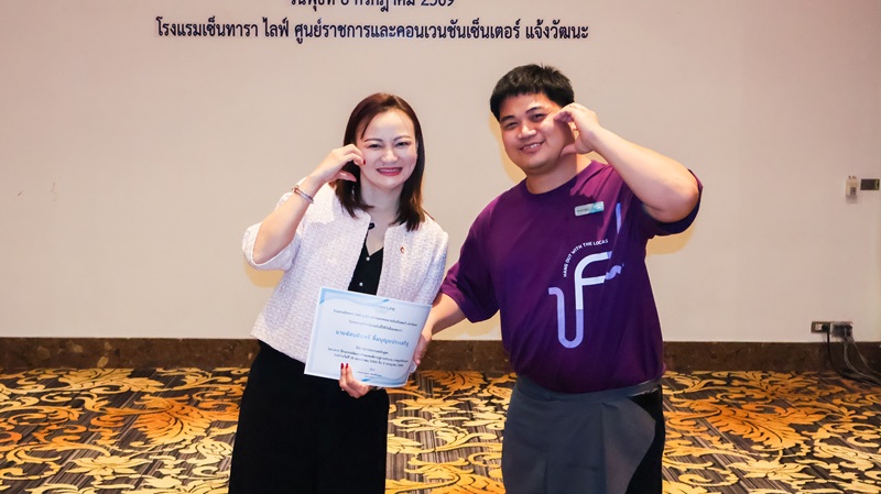 ภาพที่ 7: คุณกาญจนา เรืองสิริวิชญกุล (ซ้าย) มอบประกาศนียบัตรแก่ผู้เข้าอบรมที่สวมเสื้อยืดสีม่วง (ขวา) และถ่ายภาพร่วมกัน