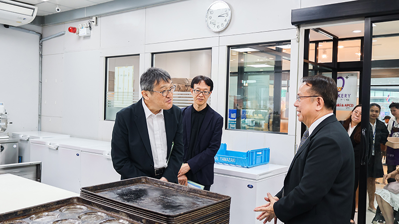 Picture 8: Mr. Piroon Laismit (right) provides information about APCD 60+ Bakery and Chocolate Café to Mr. KOBAYASHI Hiroyuki (left) and Mr. SAKUDO Shunsuke in the background