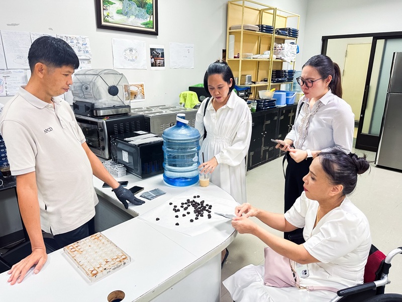 Picture 8: From left to right, Ms. Kingkarn Siriwat, Ms. Nitwari Sikon, and Ms. Nongnuch Maytarjittipun (seated in a wheelchair) taste chocolate