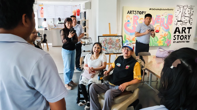 Picture 8: Ms. Nongnuch Maytarjittipun (left, seated in a wheelchair) and Mr. Krisana Lalai (right, seated in a wheelchair) talk with staff members