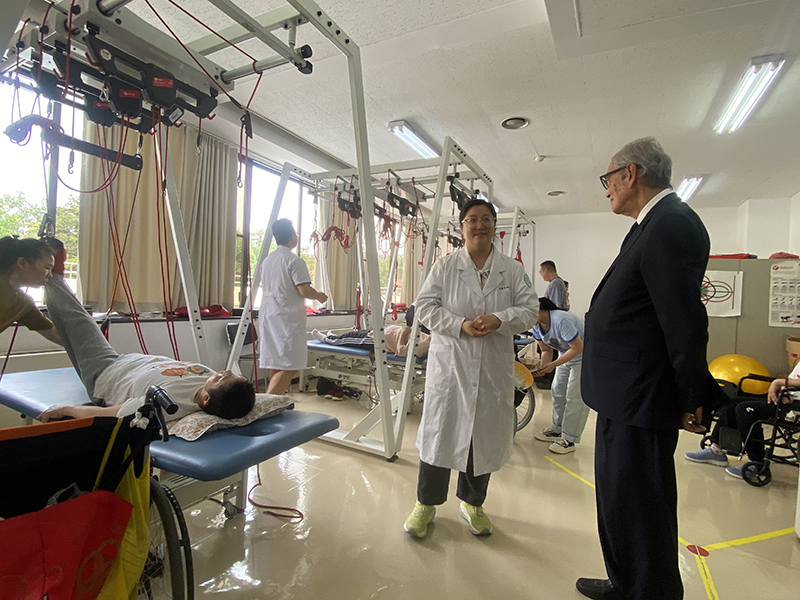 Picture 10: Dr. Tej Bunnag (right) observe a staff member (center) demonstrating physical therapy for persons with disabilities