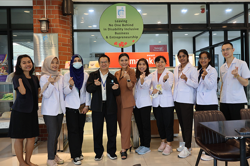 The students observed the work environment at 60+ Plus Bakery & Cafe, where people with disabilities are trained and took group photo.