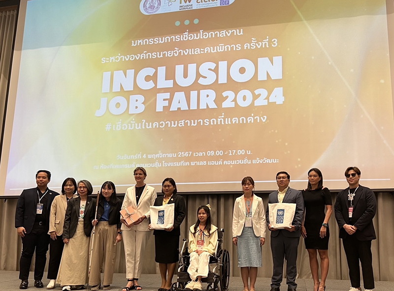 The collaborative and supportive group photo between the organizers, government sectors, private business sectors and representative person with disability. 