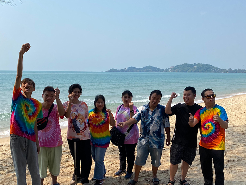 The members enjoyed a group picture beside the beach at Baan Kaival Resort.