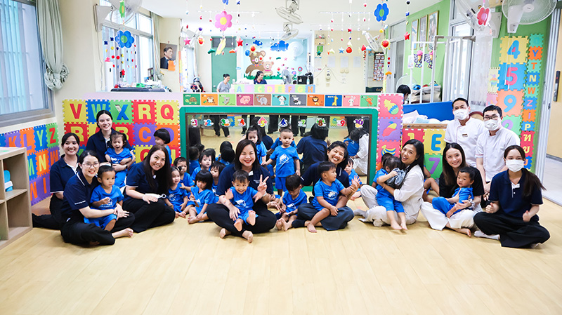 Picture 6: Group photo of team members from Millennium Hilton Bangkok and Ms. Wilailekha Somprach (third person on the right who is sitting and holding a kid), Manager of 60+ Plus.