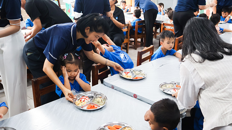 Picture 7: Team member from Millennium Hilton Bangkok is serving foods for both children in the front.