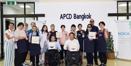 A group photo of participants from Thailand and Korea with their art workshop product.