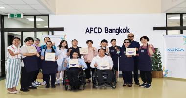 A group photo of participants from Thailand and Korea with their art workshop product.